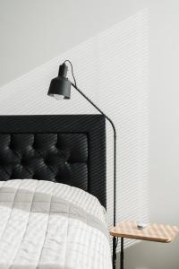 纳坦利Luxury Apartment Hovi的一间卧室配有一张床、一盏灯和一张桌子
