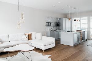 纳坦利Luxury Apartment Hovi的一间带白色沙发的客厅和一间厨房
