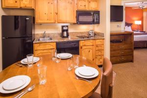 圣达菲圣达菲钻石度假村公寓式酒店的厨房配有带盘子和玻璃杯的桌子