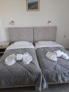 卡拉马基Knossos Hotel的卧室内的两张床和毛巾
