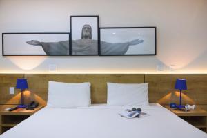 里约热内卢B&B HOTEL Rio Copacabana Forte的卧室配有一张墙上有两张照片的床。