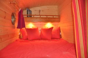 Outines埃尔夫斯大篷车度假屋，隐秘之地的木制客房内的一张红色床