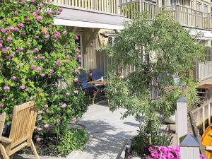 斯特伦斯塔德7 person holiday home in STR MSTAD的一个带鲜花和桌椅的庭院
