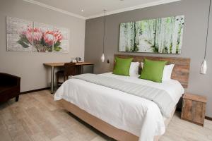 内尔斯普雷特Vinique Guesthouse的一间卧室配有一张带绿色枕头的大床