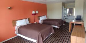 圣安东尼奥米申旅馆的橙色墙壁的酒店客房内的两张床