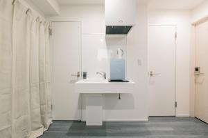 东京ZAITO Tokyo Chitose Accommodation 森下駅から徒歩6分的白色的浴室设有水槽和肥皂机