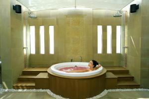 北芭堤雅Dusit Thani Pattaya的男人在浴室的大浴缸里