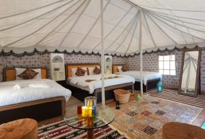 ShāhiqAlsarmadi Desert Camp的一间带两张床和帐篷的卧室
