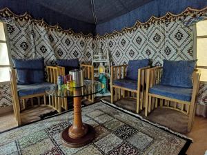 ShāhiqAlsarmadi Desert Camp的客厅配有桌椅和墙壁