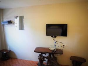 北碧T & T Hostel Kanchanaburi的墙上配有平面电视的房间