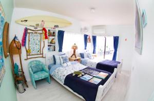 胜浦市斯普莱西旅馆的一间卧室设有两张床,墙上设有冲浪板。