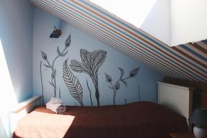 沃鲁莫爱萨艾特宾馆的卧室配有一张挂着花壁画的床。