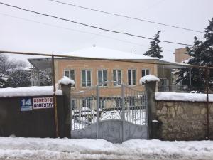 库塔伊西Giorgi's Homestay的雪覆盖的房子前的大门
