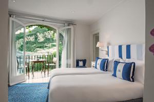 卡普里卡普里JK酒店的酒店客房设有两张床和一个阳台。
