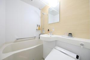 长野Hotel NewNagano NeXT的浴室设有白色浴缸、水槽和镜子
