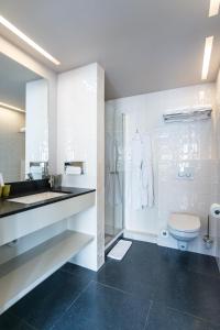 波佩林赫Hotel de la Paix的白色的浴室设有卫生间和水槽。