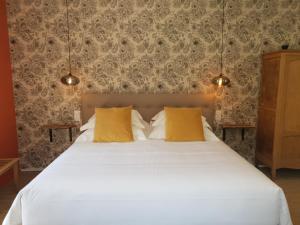 塔恩河畔里维耶尔Le Sahuc的卧室配有一张带黄色枕头的大型白色床。