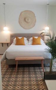 塔恩河畔里维耶尔Le Sahuc的一张带橙色枕头的床和一张桌子