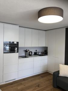 伦策海德Ferienwohnung 405 Haus Allod的厨房配有白色橱柜和大型灯具