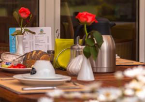Sulsdorf auf FehmarnLindenhof Hotel Garni的一张木桌,桌子上花瓶装有鲜花