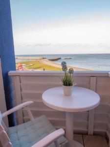 黑尔戈兰岛尼克尔斯公寓的一张桌子和两把椅子以及一扇享有海景的窗户