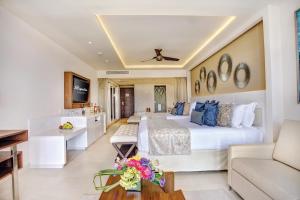 莫雷洛斯港Royalton Riviera Cancun, An Autograph Collection All-Inclusive Resort & Casino的酒店客房设有一张大床和一张沙发。