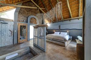 温特和克Naankuse Lodge的一间带一张床的卧室,位于带木制天花板的房间内