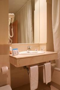 科尼尔-德拉弗龙特拉加比光之海岸酒店的一间带水槽和镜子的浴室