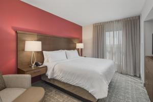 佛罗伦萨Staybridge Suites - Florence Center, an IHG Hotel的酒店客房带一张大床和一把椅子
