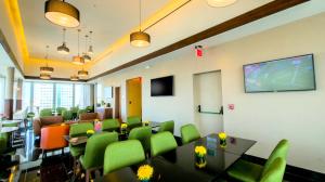 圣多明各Holiday Inn Santo Domingo, an IHG Hotel的一间会议室,配有绿色椅子和投影屏幕