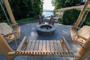 乔治湖朱莉安娜度假酒店的两个木凳,坐在带火坑的庭院