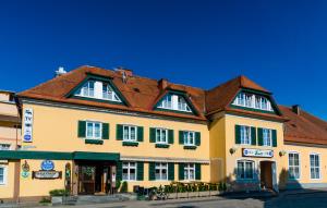 格拉茨附近卡尔斯多夫彭德尔酒店的棕色屋顶的大型黄色建筑