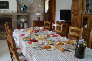 多尔德布列塔尼鲁巴台住宿加早餐酒店的一张桌子,早餐包括羊角面包和橙汁