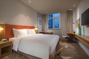 苏州苏州新区智选假日酒店的酒店客房设有一张大床和一张书桌。