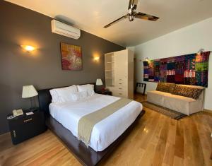 墨西哥城康德萨别墅酒店的卧室配有一张白色的大床和一张沙发。