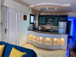 西迪基里尔Seaside Two-Bedroom Chalet Sidi Krir的厨房配有绿色橱柜和蓝色台面