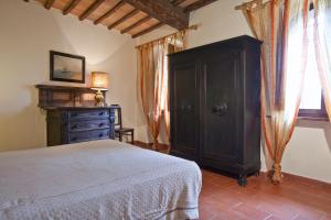 波吉邦西Agriturismo il Torrione的一间卧室配有床、橱柜和窗户