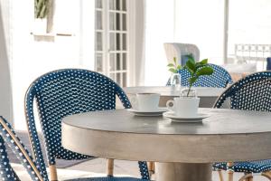 迈阿密海滩Blue Moon Hotel的桌子和椅子,上面有两杯和一株植物