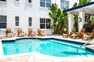 迈阿密海滩Blue Moon Hotel的一个带椅子的游泳池和一间酒店