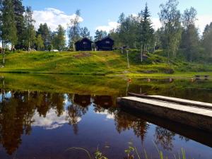 ÅmotGroven Camping & Hyttegrend的湖中小屋的反射