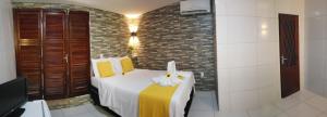 卡诺格布拉达Pousada Morena Moleca的一间卧室设有一张床和砖墙