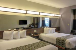 CaldwellQuality Inn & Suites的酒店客房设有两张床和电视。