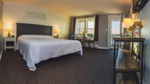 罗克波特熊皮颈汽车旅馆的一间带白色床的卧室和一个阳台
