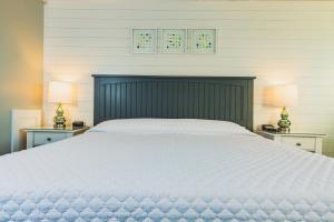 罗克波特熊皮颈汽车旅馆的一间卧室配有一张带两盏灯的大型白色床。