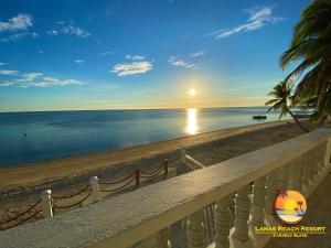 San JoseLanas Beach Resort的阳台享有日落海滩的景致。