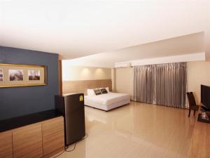 Ban Laem Chabang阿哈瓦那林查班精品酒店的一间卧室配有一张床,并在一间客房内配有电视。