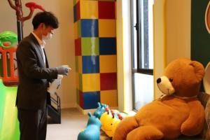 桐乡乌镇皇冠假日酒店的身着西装的人站在一个大泰迪熊旁边