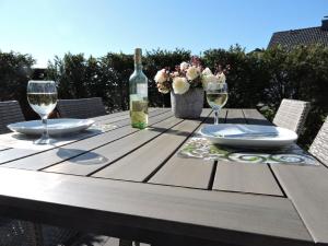 温特贝格Appartement - Haus Winterberg的一张木桌,配有一瓶葡萄酒和两杯酒