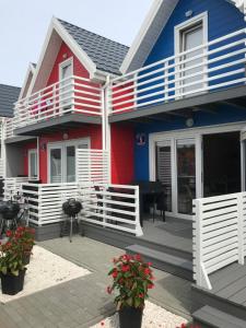 萨比诺瓦Kotwisko的红色的蓝色和白色的房子,设有门廊和钢琴