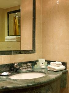基拉尼基拉尼大道酒店的浴室配有盥洗盆、镜子和毛巾